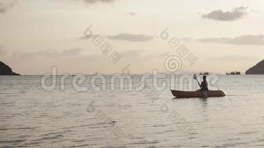 一个手里拿着桨的年轻女子正在皮艇上漂浮